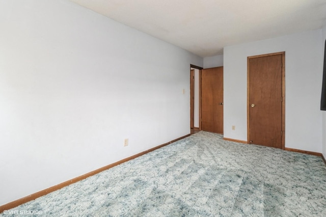 unfurnished bedroom featuring carpet flooring and baseboards