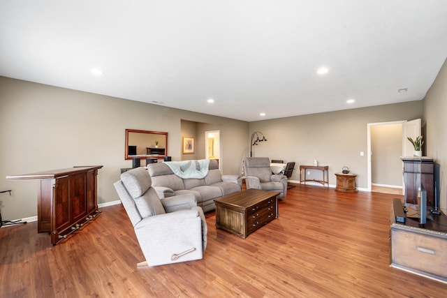 living area with recessed lighting, baseboards, and light wood finished floors