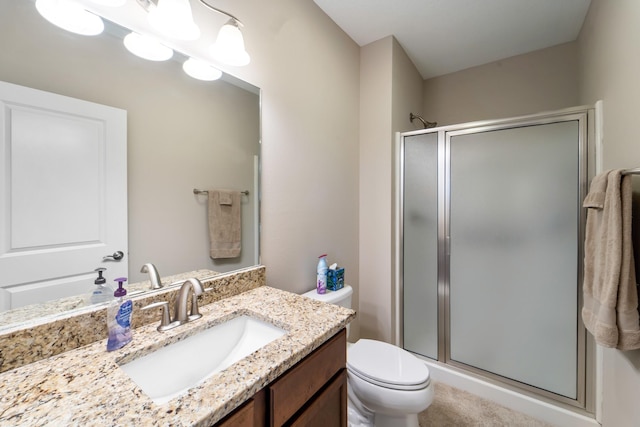 bathroom featuring vanity, a stall shower, and toilet