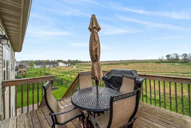 deck featuring outdoor dining area and a yard