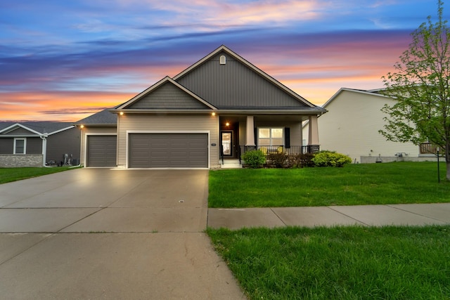 view of front of property featuring a porch, an attached garage, driveway, and a front yard