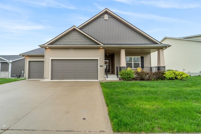craftsman house featuring covered porch, driveway, a front yard, and a garage