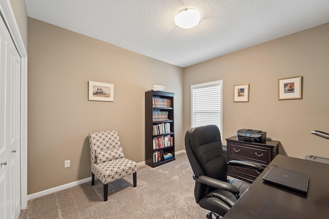 carpeted office space featuring baseboards and a textured ceiling