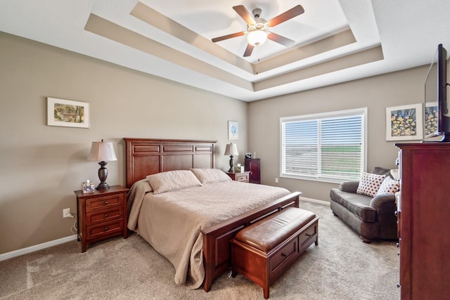 bedroom featuring baseboards, a ceiling fan, a raised ceiling, and light colored carpet