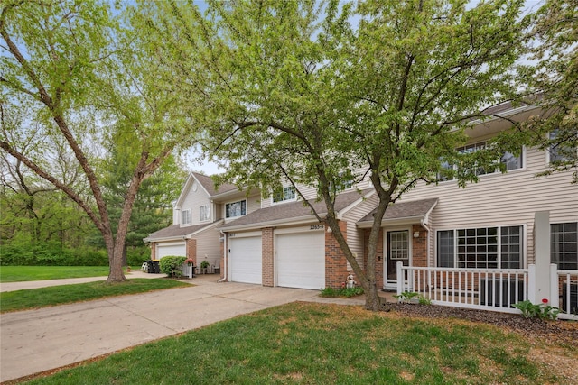 traditional-style house featuring brick siding, a front lawn, an attached garage, and driveway