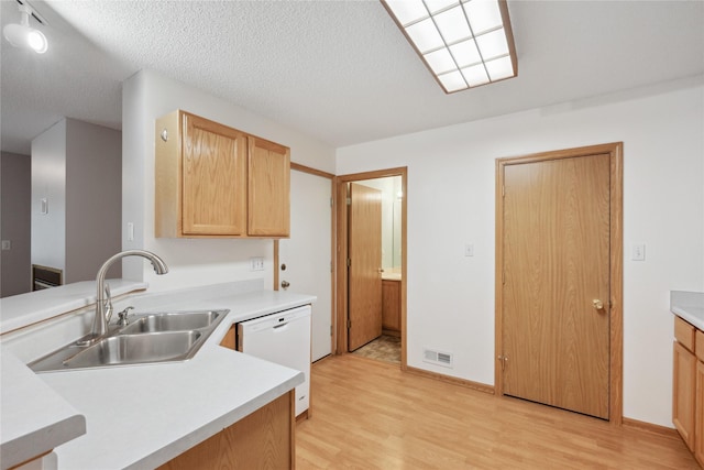 kitchen with visible vents, a sink, light wood finished floors, and dishwasher