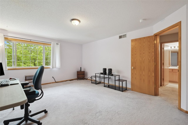 carpeted office with a textured ceiling and visible vents