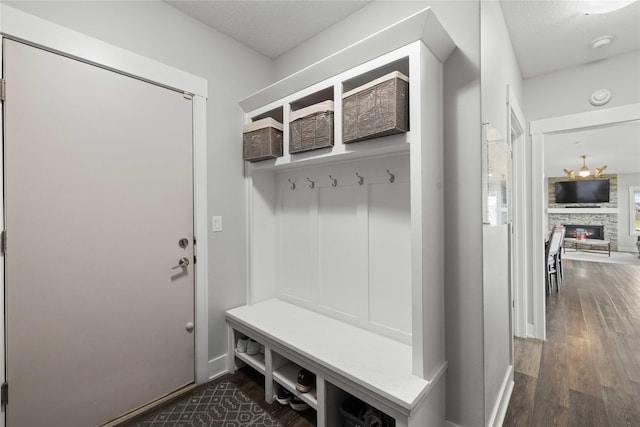 5129 NE Seneca Dr, Ankeny, IA 50021 - mudroom featuring dark wood finished floors, a stone fireplace, and a textured ceiling