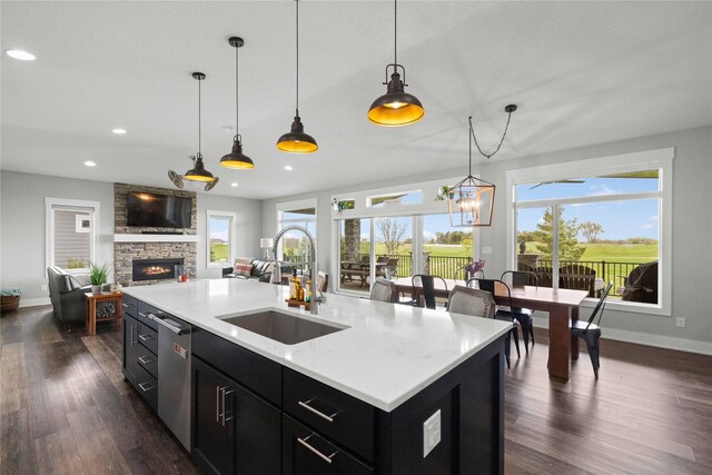 5129 NE Seneca Dr, Ankeny, IA 50021 - kitchen with dark cabinets, dishwasher, a stone fireplace, recessed lighting, and dark wood-type flooring