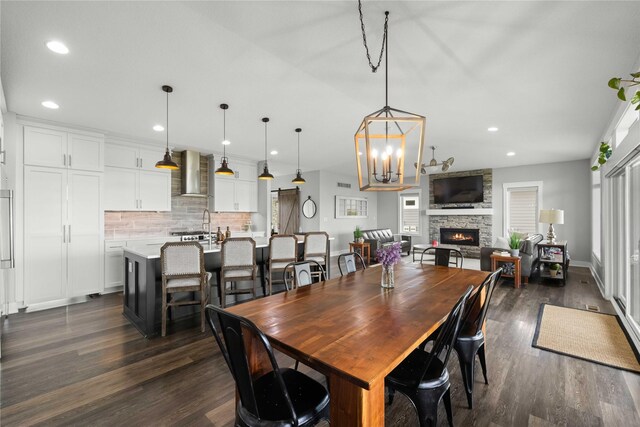 5129 NE Seneca Dr, Ankeny, IA 50021 - dining room with dark wood-style floors, a stone fireplace, recessed lighting, and a chandelier