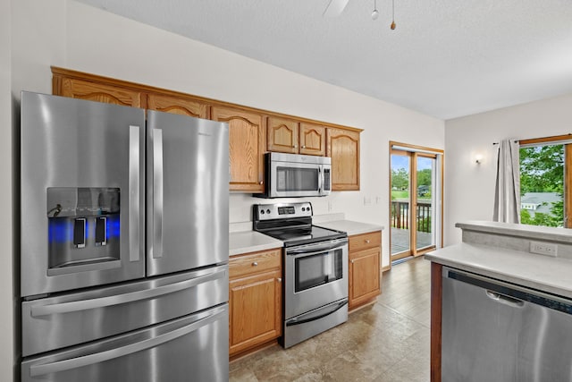 5099 Clover Ridge Rd, Panora, IA 50216 - kitchen featuring light countertops, a textured ceiling, appliances with stainless steel finishes, and brown cabinets