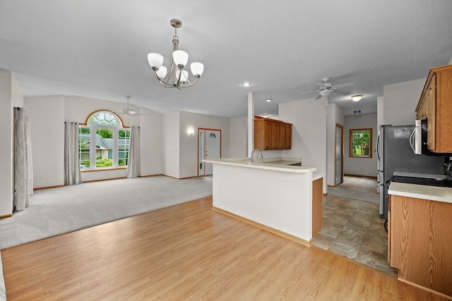 5099 Clover Ridge Rd, Panora, IA 50216 - kitchen featuring brown cabinetry, baseboards, open floor plan, light countertops, and ceiling fan with notable chandelier