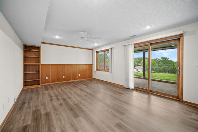 5099 Clover Ridge Rd, Panora, IA 50216 - unfurnished living room with ceiling fan, wainscoting, baseboards, wood finished floors, and visible vents