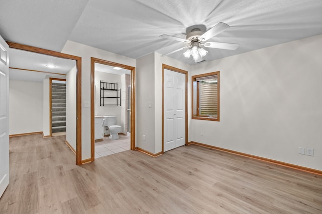 5099 Clover Ridge Rd, Panora, IA 50216 - unfurnished bedroom with light wood-style floors, connected bathroom, baseboards, and ceiling fan