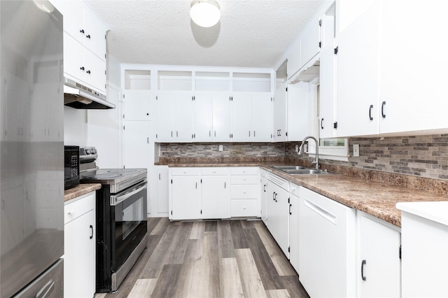 kitchen with appliances with stainless steel finishes, tasteful backsplash, wood finished floors, a sink, and under cabinet range hood