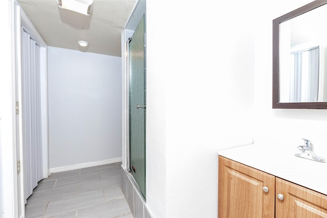 bathroom featuring vanity and a shower with door