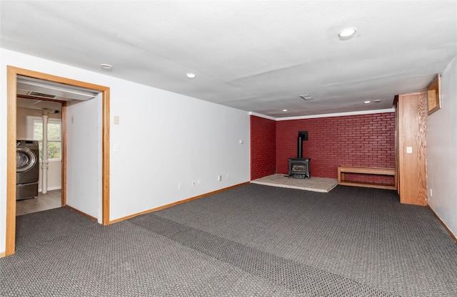 interior space with a wood stove, dark colored carpet, baseboards, washer / clothes dryer, and recessed lighting