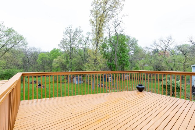 wooden terrace featuring a lawn