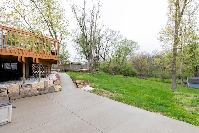 view of yard with a wooden deck, fence, and a patio