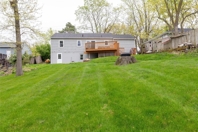 back of house featuring a wooden deck, a yard, and fence
