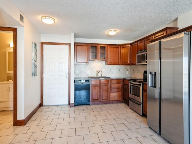 300 Walnut St Unit 1407, Des Moines, IA 50309 - kitchen with stainless steel appliances, dark countertops, backsplash, glass insert cabinets, and a textured ceiling