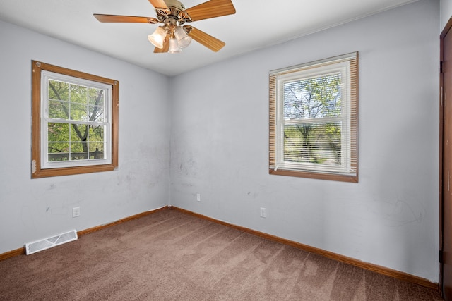unfurnished room featuring baseboards, ceiling fan, carpet, and visible vents