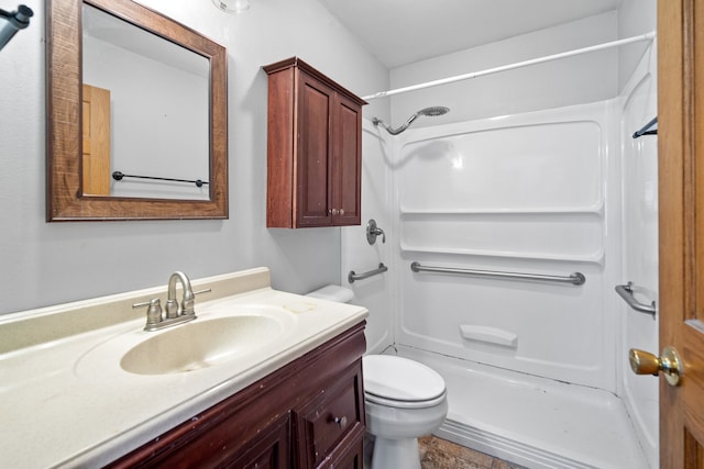 bathroom with vanity, toilet, and a shower