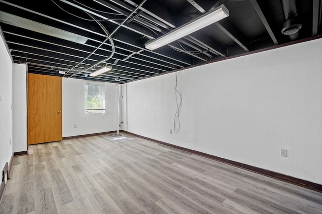 basement with baseboards and wood finished floors