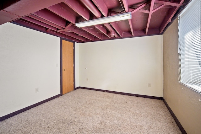 carpeted spare room featuring baseboards and a wealth of natural light