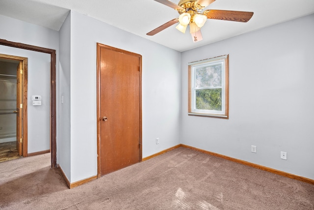 unfurnished bedroom with baseboards, carpet, ceiling fan, and a closet