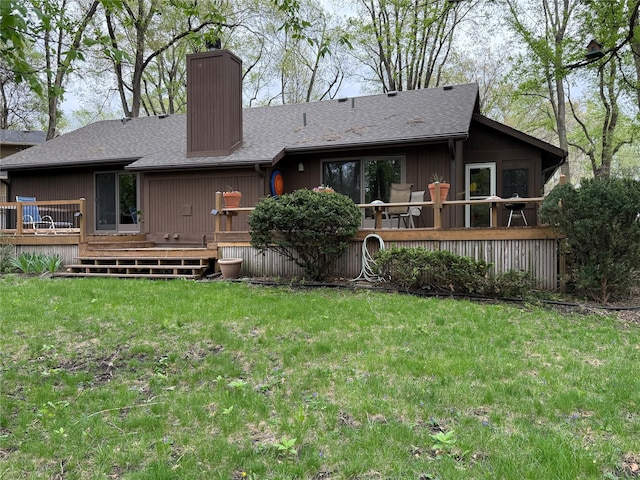 back of property with a yard, a chimney, a shingled roof, and a wooden deck