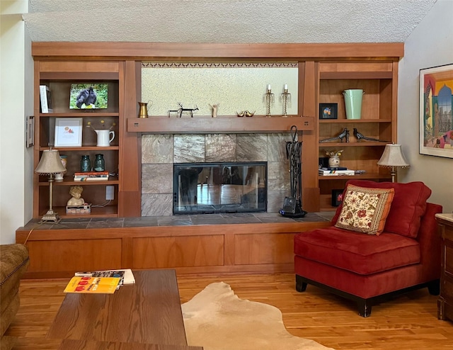 956 55th St, West Des Moines, IA 50266 - living area featuring a textured ceiling, a tile fireplace, and wood finished floors