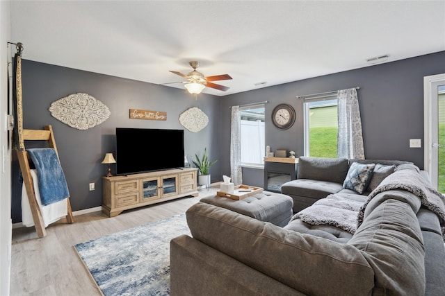 living room with baseboards, ceiling fan, wood finished floors, and visible vents