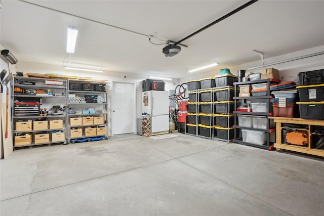 garage featuring freestanding refrigerator and a garage door opener