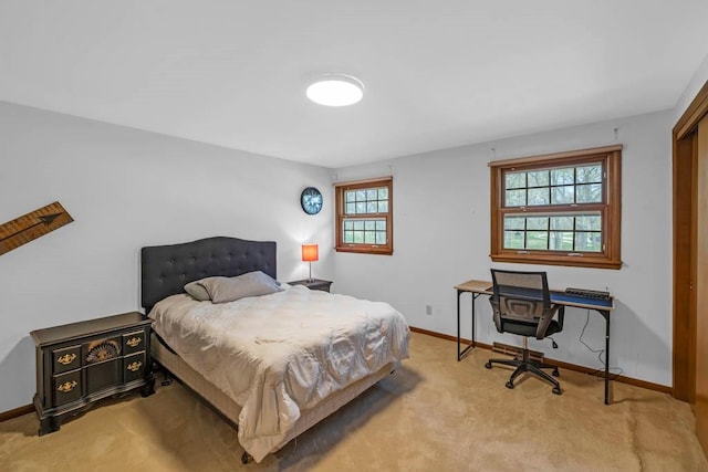 bedroom featuring baseboards and light carpet