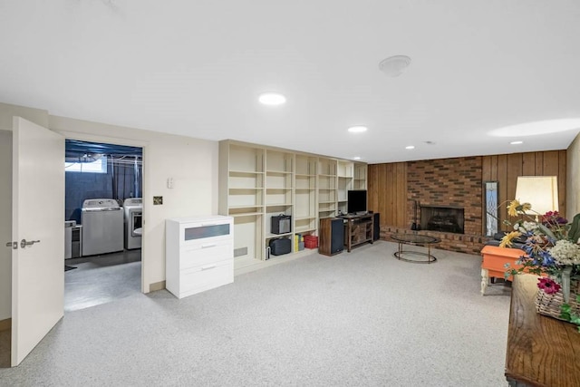 living room featuring recessed lighting, washer and clothes dryer, and a fireplace