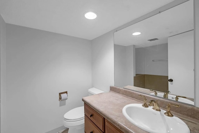 bathroom featuring vanity, toilet, and visible vents