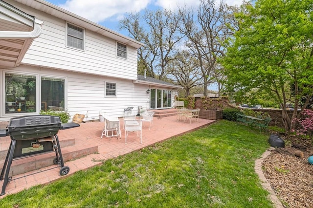 rear view of house with a lawn and a patio