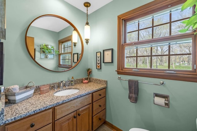 half bath with vanity, baseboards, and toilet