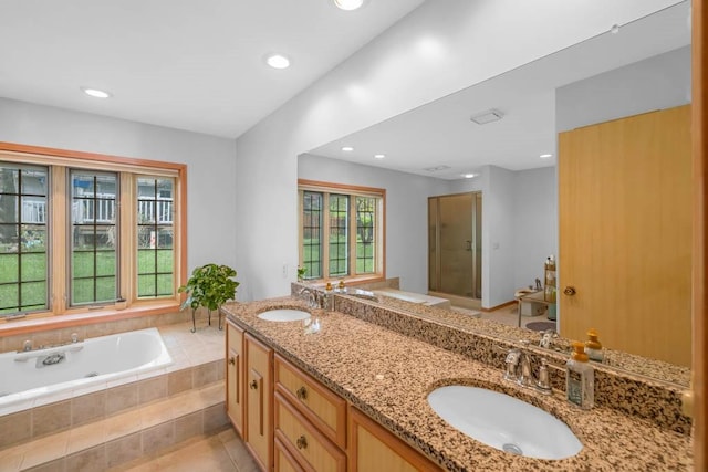 bathroom featuring double vanity, recessed lighting, a sink, and a bath