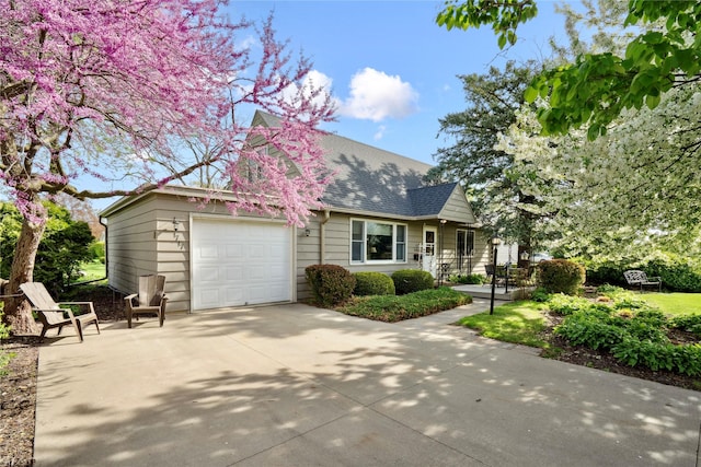 view of front facade featuring a shingled roof, an attached garage, and concrete driveway