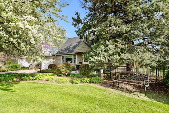 view of front of house with roof with shingles, fence, and a front yard