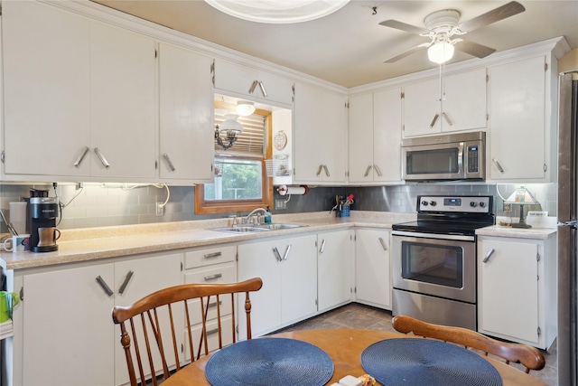kitchen with light countertops, appliances with stainless steel finishes, decorative backsplash, and a sink