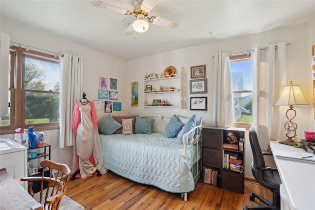 bedroom featuring multiple windows, a ceiling fan, and wood finished floors