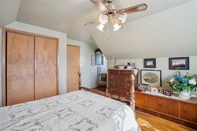 bedroom with wood finished floors, ceiling fan, lofted ceiling, and a closet