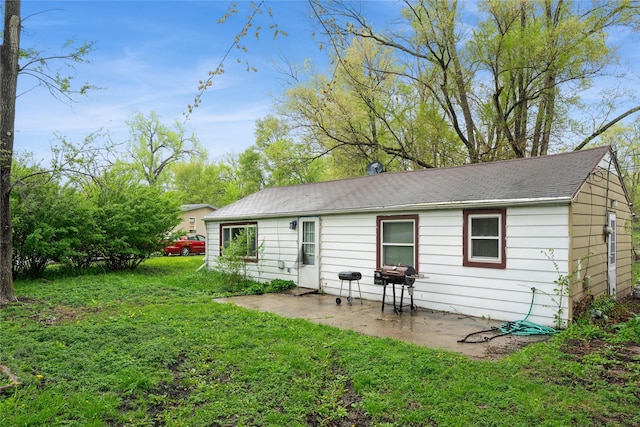 rear view of property featuring a lawn and a patio