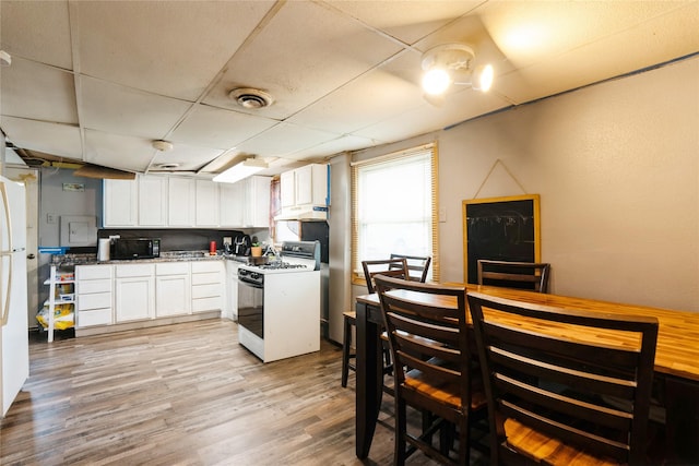kitchen with black microwave, gas range gas stove, white cabinetry, a paneled ceiling, and under cabinet range hood