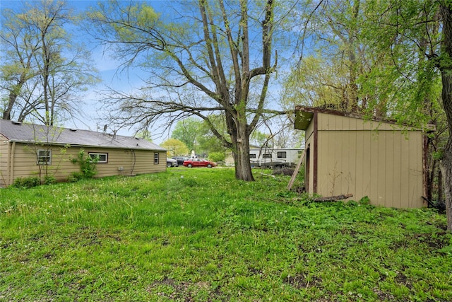 view of yard featuring a storage shed and an outbuilding