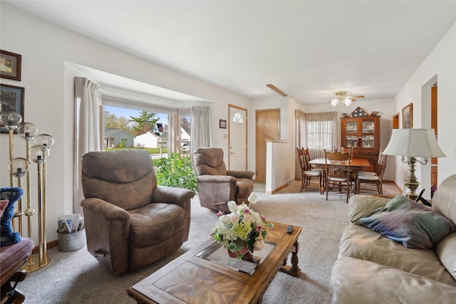 carpeted living area featuring ceiling fan