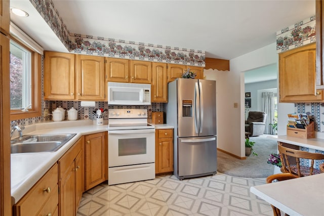 kitchen with a sink, light countertops, tasteful backsplash, and white appliances